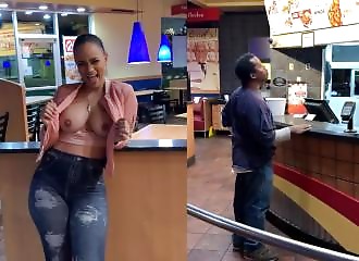 She's flaunting her breasts right next to a customer in a restaurant.